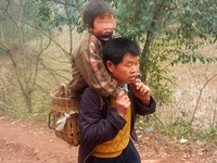 Отцовская любовь: Китаец носит сына-инвалида в школу на спине